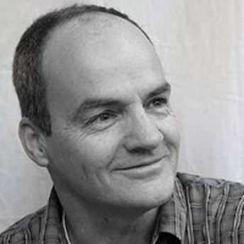 Zwart-wit portret van man met lichte glimlach.