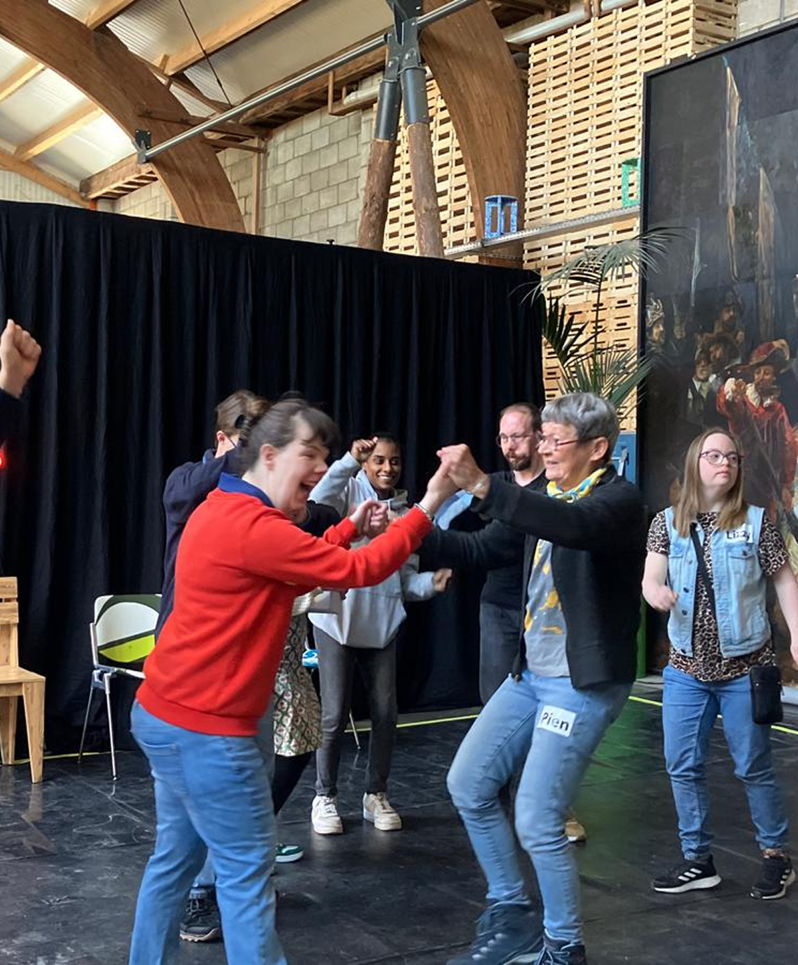 Groep jongeren dansen tijdens theaterscène.