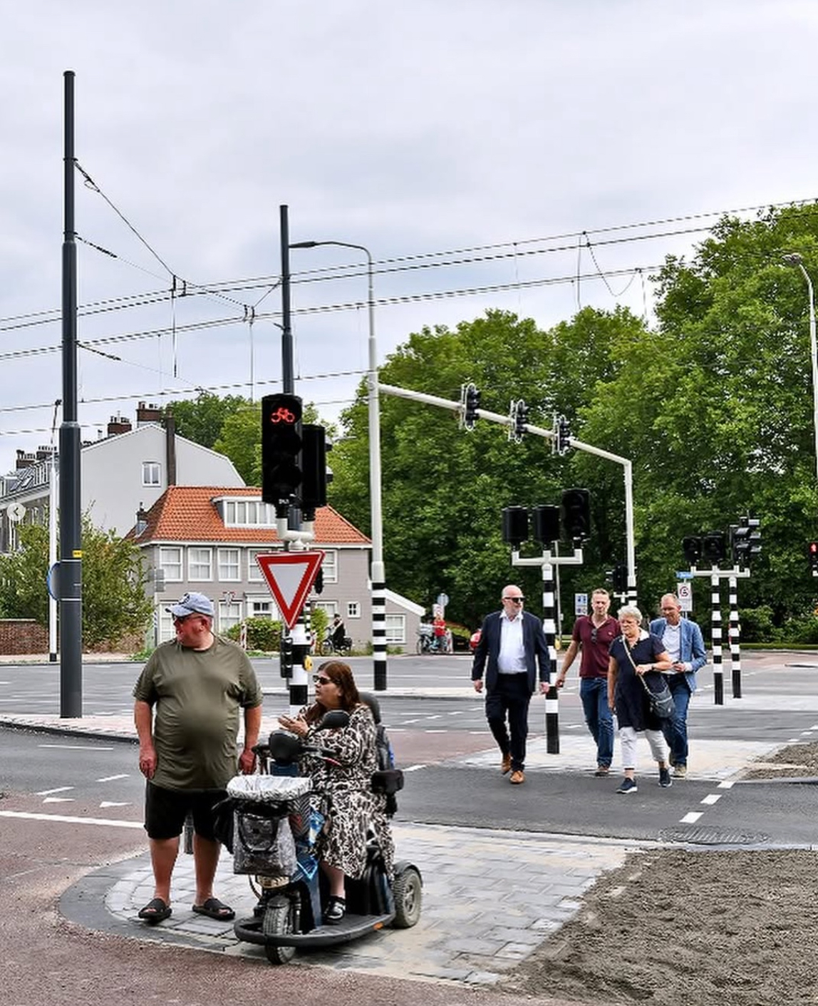 Inclusief kruispunt straatbeeld met fietsers en tram bij kruising.