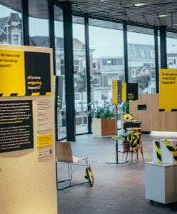 Wand met verschillende panelen in geel, zwart en blauw over toegankelijkheid.