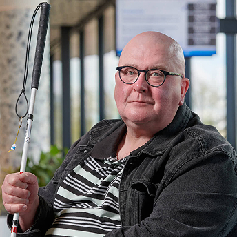 Portret van man met bril, zittend in tram of bus.